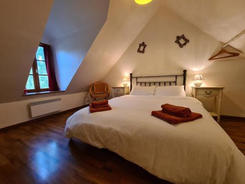 a bedroom with a large white bed in a attic at Ancien moulin avec piscine, terrasse, jardin privatif et petite île - près des étangs de la Brenne - FR-1-591-159 in Prissac