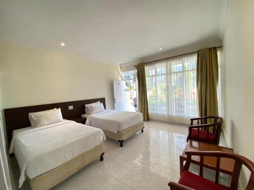 a hotel room with two beds and a window at Khas Parapat in Parapat