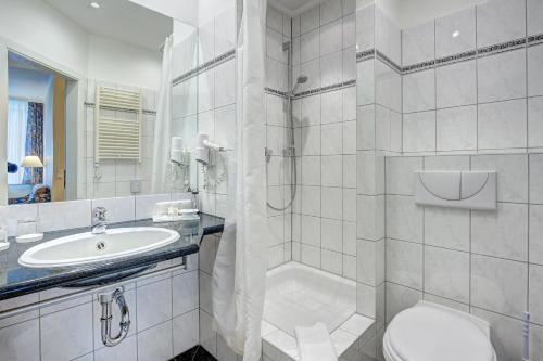 a white bathroom with a toilet and a sink at Haus Seeblick Hotel Garni & Ferienwohnungen in Zinnowitz