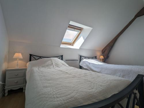 2 Betten in einem Schlafzimmer im Dachgeschoss mit Fenster in der Unterkunft Gîte Frédille, 3 pièces, 4 personnes - FR-1-591-235 