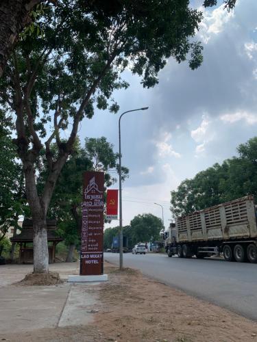 um sinal no lado de uma rua com um camião em HotelLaoMixay em Savannakhet