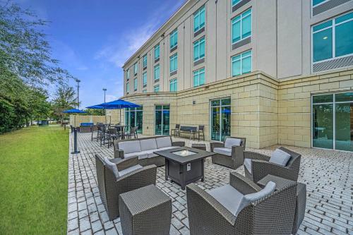 a patio with chairs and tables in front of a building at Holiday Inn Express and Suites North Charleston, an IHG Hotel in Charleston