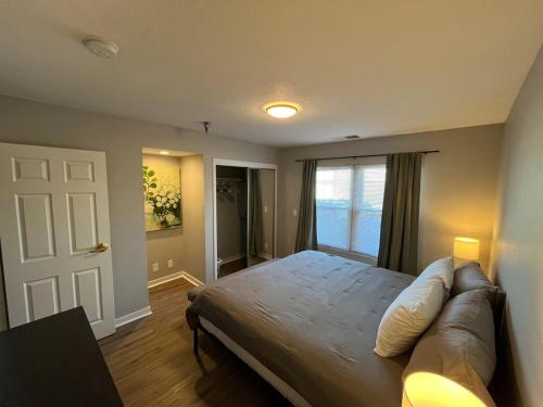 a bedroom with a large bed and a window at Aksarben 1 Bedroom-Close to I-80 in Omaha