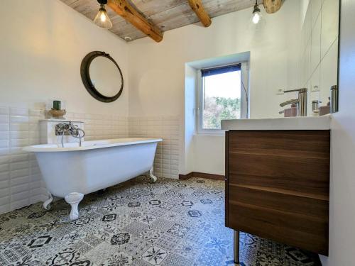 a bathroom with a tub and a sink and a mirror at Ancienne ferme rénovée avec jardin privé, poêle à bois et terrasse - FR-1-582-44 in Saint-Préjet-dʼAllier