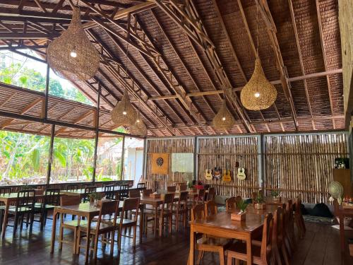 un restaurante con mesas de madera, sillas y luces en 3WILL Bunaken Dive Resort, en Bunaken