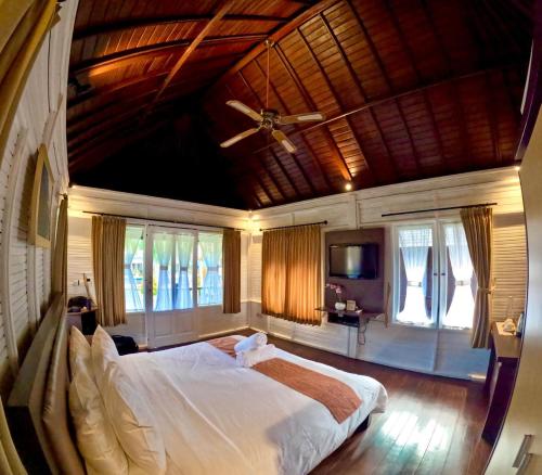 a bedroom with a large bed with a wooden ceiling at Balangan Surf Resort in Jimbaran