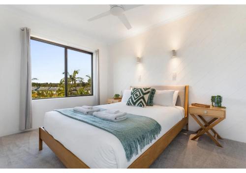 a bedroom with a bed with a large window at Noosa Riverside Getaway in Noosa Heads