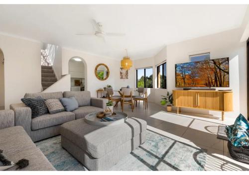 a living room with a couch and a table at Noosa Riverside Getaway in Noosa Heads