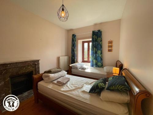 une chambre avec deux lits et une cheminée dans l'établissement Maison de caractère avec piscine, 8 pers, proche Puy du Fou et Nantes - FR-1-426-137, à Cugand