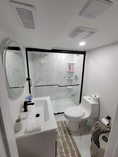 a bathroom with a toilet and a sink and a shower at One Bedroom Apartment in Ajax