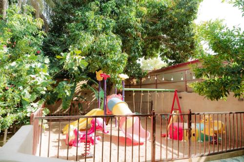 a fence with a play equipment in a yard at Hatta Orchard in Hatta