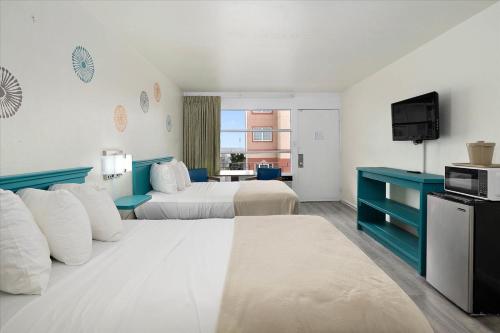 um quarto de hotel com duas camas e uma televisão em Eden Roc Ocean Side em Ocean City