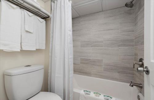 a bathroom with a toilet and a tub and a shower at Eden Roc Ocean Side in Ocean City