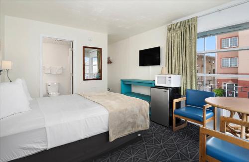 a hotel room with a bed and a table and chair at Eden Roc Motel in Ocean City