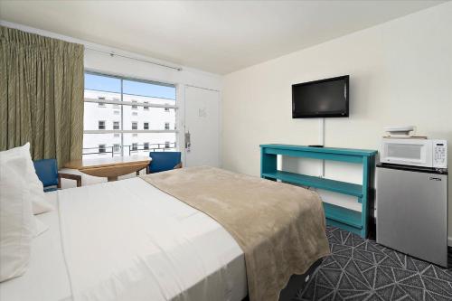 a hotel room with a bed and a tv at Eden Roc Motel in Ocean City
