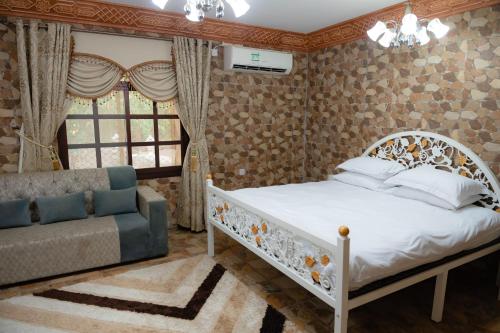 a bedroom with a bed and a couch at Alsalam Farmhouse in Hatta