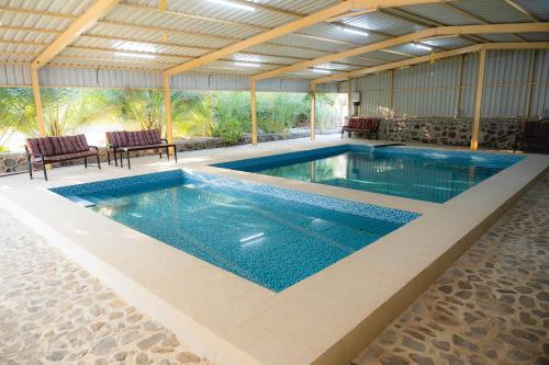 a large swimming pool in a building with a poolvisor at Alsalam Farmhouse in Hatta