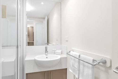 a white bathroom with a sink and a mirror at Botanical- Edge Hill Village in Edge Hill