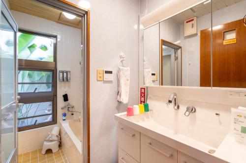 uma casa de banho com um lavatório e um chuveiro em Beach House Yomitan em Yomitan