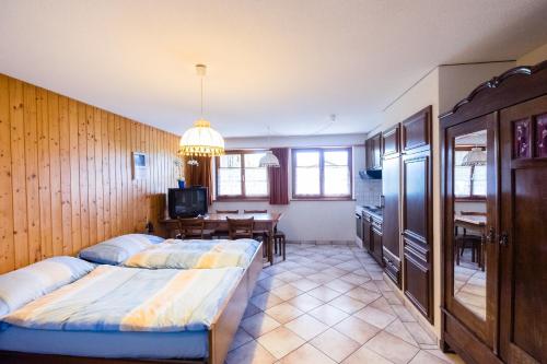 a bedroom with two beds and a kitchen with a table at Hôtel-Gîte rural à 3 km de Delémont in Courcelon