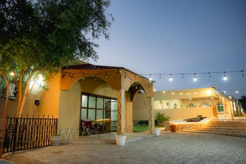 a house with a patio and a string of lights at Wadi Alsidra in Hatta
