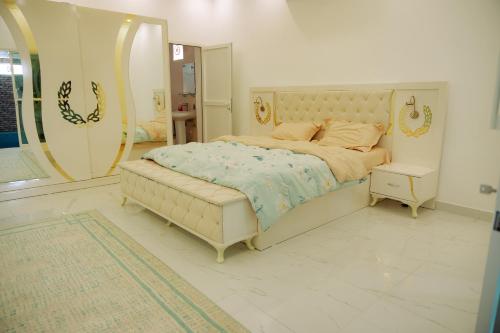 a bedroom with a large bed and a large mirror at Al Fay Farmhouse in Sinādil