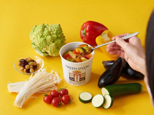 a person eating food from a can on a table with vegetables at Hotel Wing International Select Ikebukuro in Tokyo