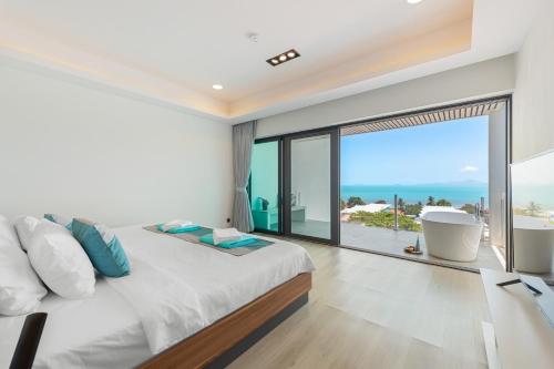 a bedroom with a large bed and a view of the ocean at Master Peak H4 - Seaside Serenity 4 Bedrooms Villa with Cinema, Fitness and Pool in Amphoe Koksamui