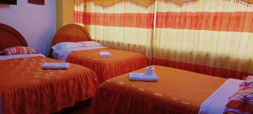 a room with two beds with towels on them at HOSTAL ACUARIUS PUNO in Puno