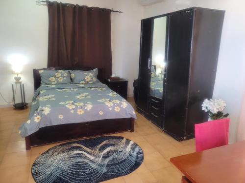 una camera con letto, cassettiera e tavolo di Appt-Weber a Gibuti
