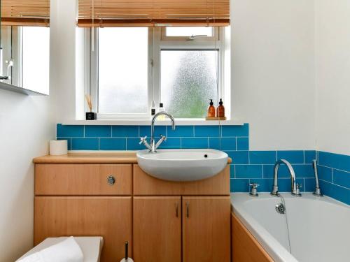 ein Badezimmer mit einem Waschbecken und einer Badewanne in der Unterkunft Pass the Keys Classy house in Llanishen in Cardiff
