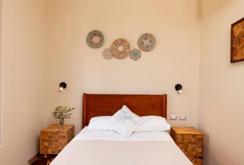 Un dormitorio con una cama y platos en la pared en Acari Hotel Resort 