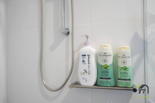 a shelf with three bottles of soap and a shower at Vivid Condo 1B1B in Bankstown in Bankstown