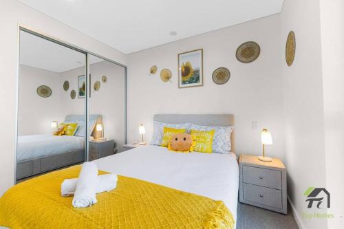 a bedroom with a large bed with a yellow blanket at Vivid Condo 1B1B in Bankstown in Bankstown