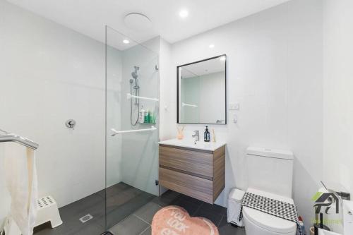 a bathroom with a toilet and a sink and a mirror at Vivid Condo 1B1B in Bankstown in Bankstown