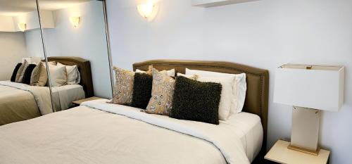 a bedroom with a bed with pillows and a mirror at NYC Loft Brisbane in Brisbane