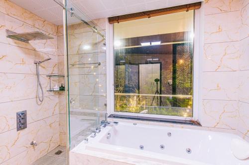 ein Bad mit einer Badewanne und einem Fenster in der Unterkunft Villa FLC Sầm Sơn - Sao Biển 101 in Sầm Sơn