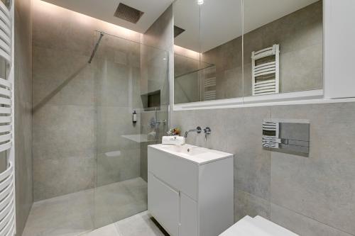 y baño con lavabo blanco y ducha. en Lion Apartments - Sopot Fresh Wave Apartment with terrace and parking en Sopot