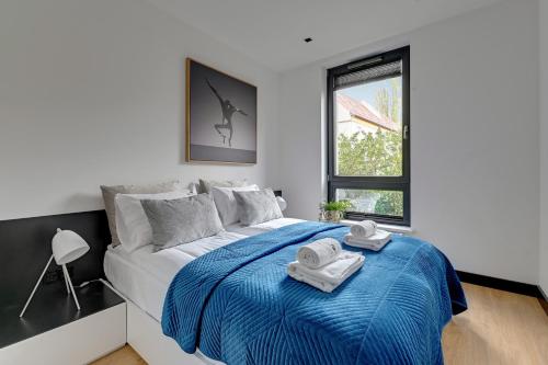 1 dormitorio con 1 cama con 2 toallas en Lion Apartments - Sopot Fresh Wave Apartment with terrace and parking en Sopot