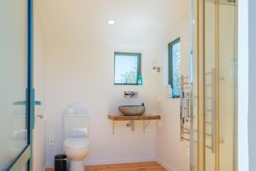 a bathroom with a toilet and a sink at Awaawa Yurts - Tane Yurt in Palm Beach