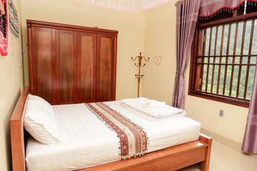 a bedroom with a bed and a window at Wind's House Ha Giang in Ha Giang