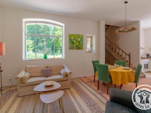 un salon avec un canapé et une table dans l'établissement Maison ancienne rénovée avec jardin, animaux admis, parking - près de Baugé - FR-1-622-58, à Baugé