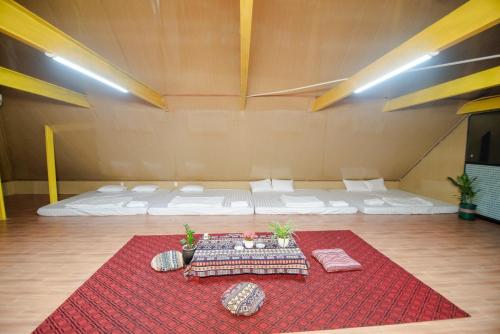 a room with two beds and a red rug at Wind's House Ha Giang in Ha Giang