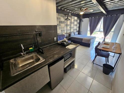 a kitchen with a sink and a table and a bed at Depas MiniLoft in Guadalajara