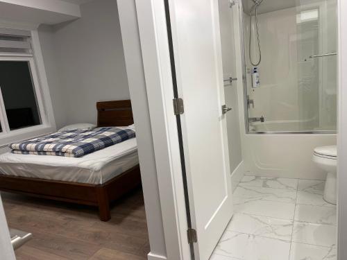łazienka z łóżkiem, prysznicem i toaletą w obiekcie Auspicious Sea View House w mieście Nanaimo
