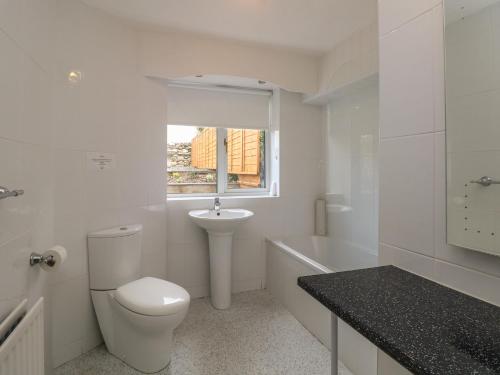 a white bathroom with a toilet and a sink at The Heights in Bowness-on-Windermere