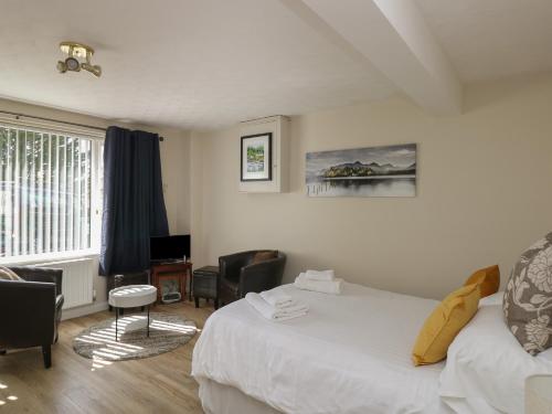 a hotel room with a bed and chairs and a window at The Heights in Bowness-on-Windermere
