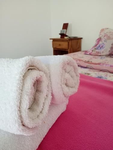 een witte handdoek op een bed met een bureau bij Posada la Península in Gualeguaychú
