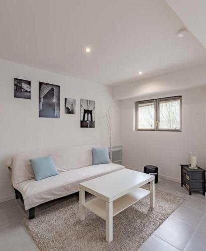Sala de estar blanca con sofá y mesa en GuestReady - Modern and Spacious Flat near Vaise, en Lyon