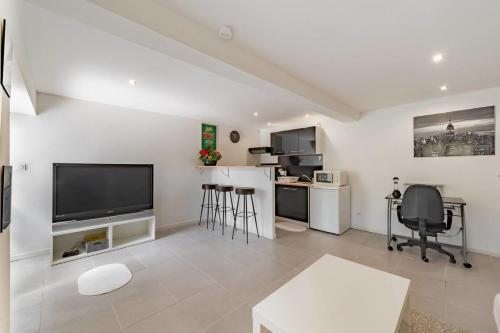 sala de estar blanca con TV de pantalla plana en GuestReady - Modern and Spacious Flat near Vaise, en Lyon